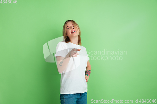 Image of Caucasian young woman\'s portrait on green studio background