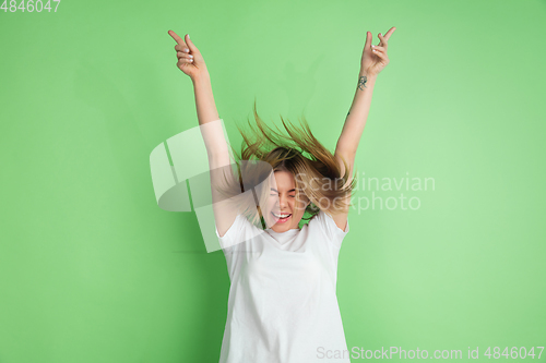 Image of Caucasian young woman\'s portrait on green studio background