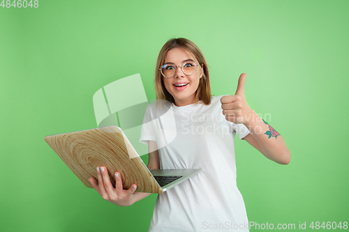 Image of Caucasian young woman\'s portrait on green studio background