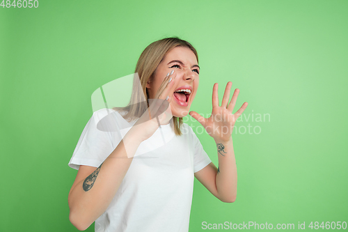 Image of Caucasian young woman\'s portrait on green studio background