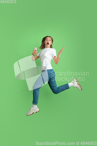 Image of Caucasian young woman\'s portrait on green studio background
