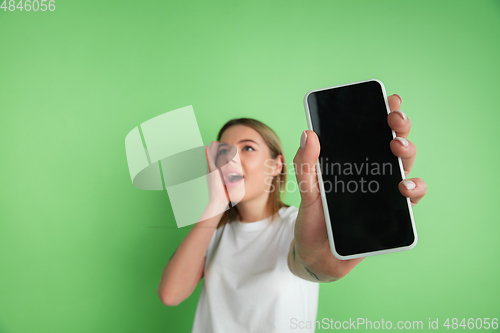 Image of Caucasian young woman\'s portrait on green studio background