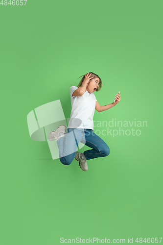 Image of Caucasian young woman\'s portrait on green studio background