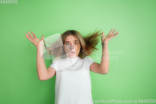 Image of Caucasian young woman\'s portrait on green studio background