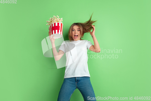 Image of Caucasian young woman\'s portrait on green studio background