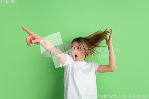Image of Caucasian young woman\'s portrait on green studio background