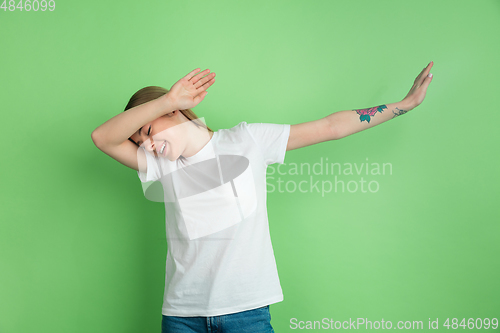 Image of Caucasian young woman\'s portrait on green studio background