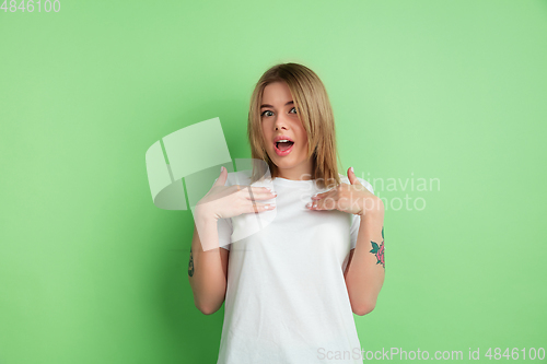 Image of Caucasian young woman\'s portrait on green studio background