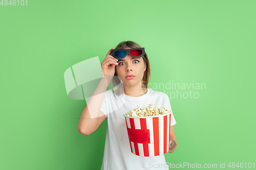 Image of Caucasian young woman\'s portrait on green studio background