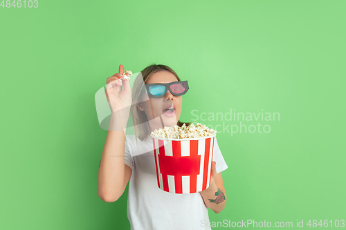 Image of Caucasian young woman\'s portrait on green studio background