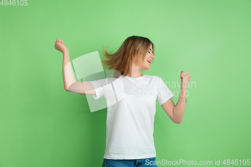 Image of Caucasian young woman\'s portrait on green studio background