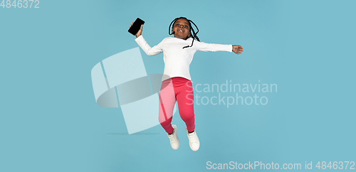 Image of Handsome african little girl portrait isolated on blue studio background with copyspace