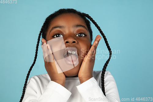 Image of Handsome african little girl portrait isolated on blue studio background with copyspace