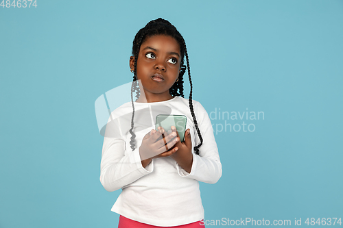 Image of Handsome african little girl portrait isolated on blue studio background with copyspace