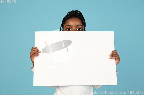 Image of Handsome african little girl portrait isolated on blue studio background with copyspace