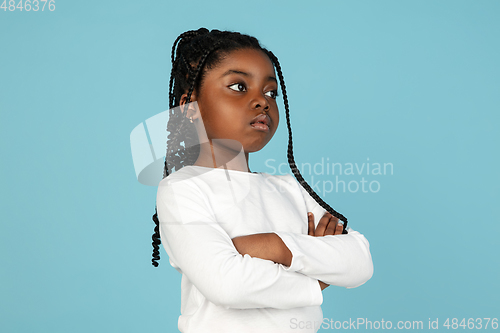 Image of Handsome african little girl portrait isolated on blue studio background with copyspace