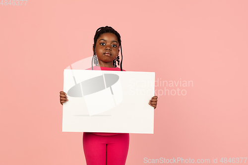 Image of Handsome african little girl portrait isolated on pink studio background with copyspace