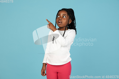 Image of Handsome african little girl portrait isolated on blue studio background with copyspace