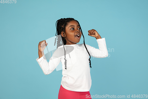 Image of Handsome african little girl portrait isolated on blue studio background with copyspace