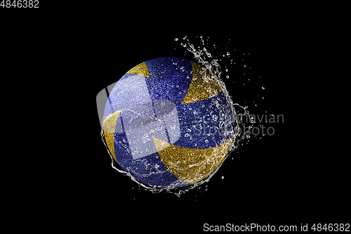 Image of Volleyball ball flying in water drops and splashes isolated on black background