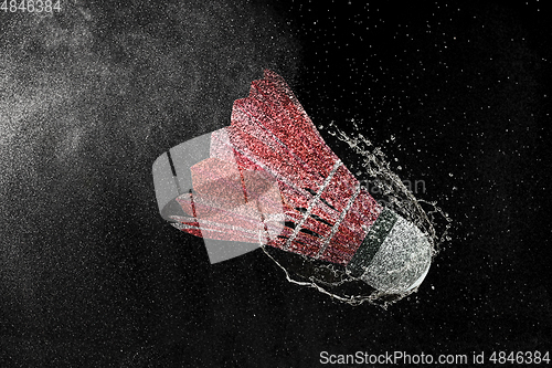 Image of Shuttlecock in water drops and splashes isolated on black background