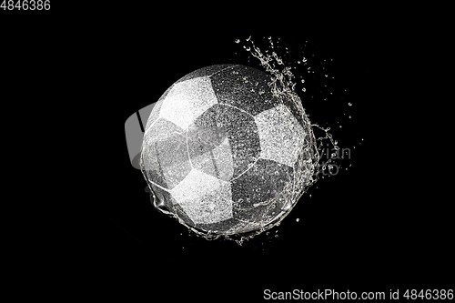 Image of Football, soccer ball flying in water drops and splashes isolated on black background