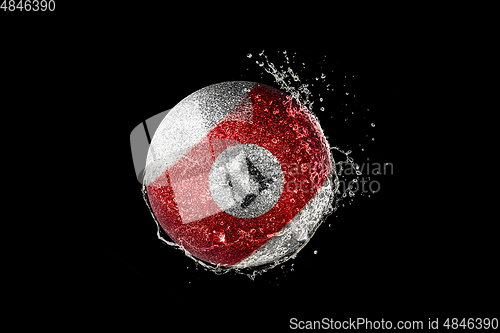 Image of Billiards ball flying in water drops and splashes isolated on black background