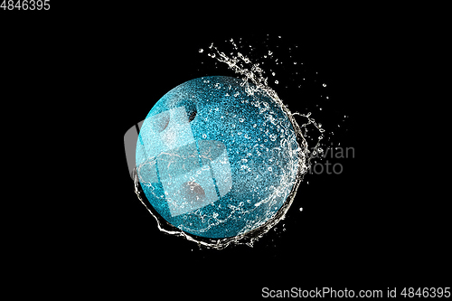 Image of Bowling ball in water drops and splashes isolated on black background