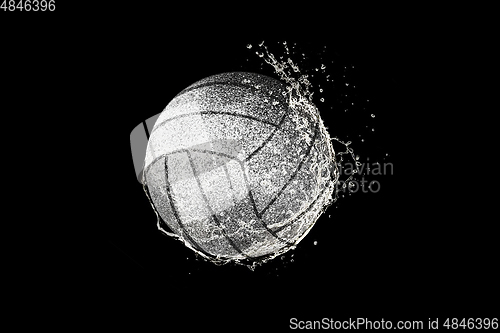 Image of Volleyball ball flying in water drops and splashes isolated on black background