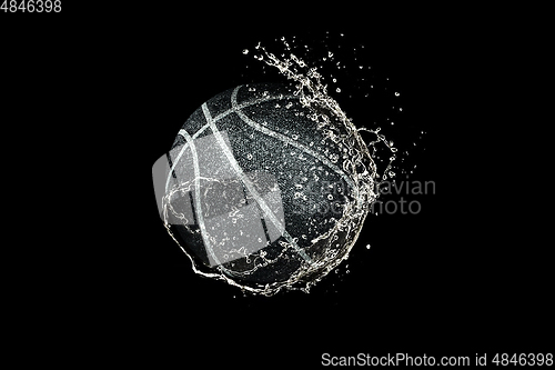 Image of Basketball ball flying in water drops and splashes isolated on black background