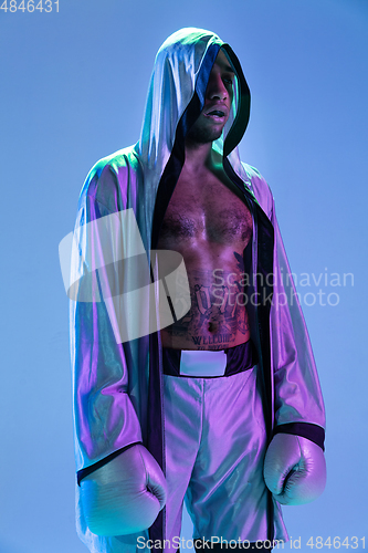 Image of High-fashion styled man in white outfit pacticing box isolted over gradient background in neon light