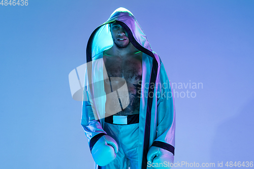 Image of High-fashion styled man in white outfit pacticing box isolted over gradient background in neon light