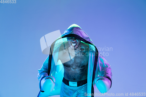 Image of High-fashion styled man in white outfit pacticing box isolted over gradient background in neon light