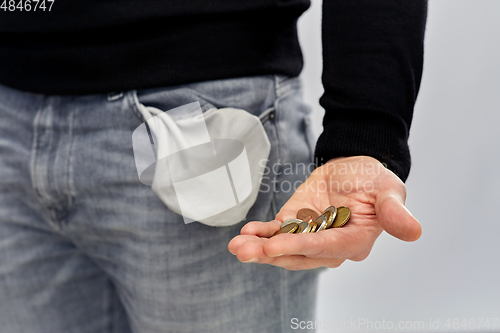 Image of close up of man showing coins and empty pockets