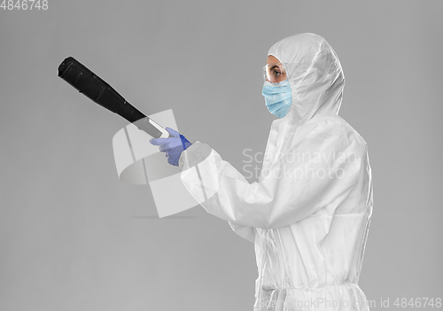 Image of sanitation worker in hazmat with pressure washer