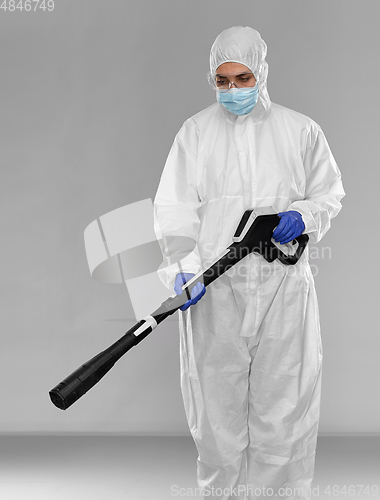 Image of sanitation worker in hazmat with pressure washer