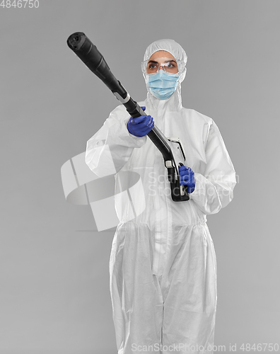 Image of sanitation worker in hazmat with pressure washer