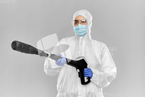 Image of sanitation worker in hazmat with pressure washer