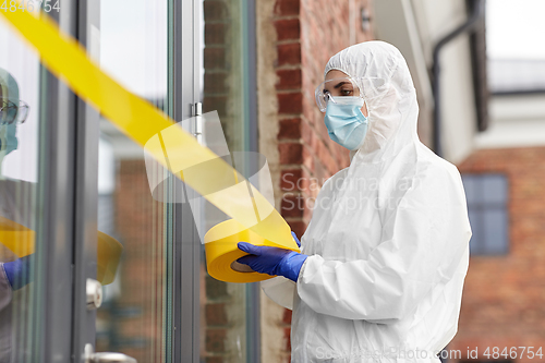 Image of healthcare worker sealing door with caution tape