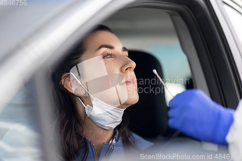 Image of healthcare worker making coronavirus test at car