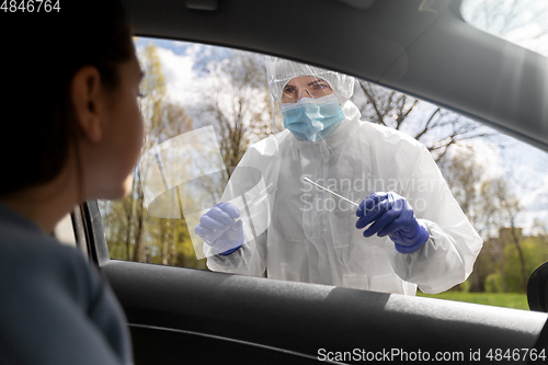 Image of healthcare worker making coronavirus test at car