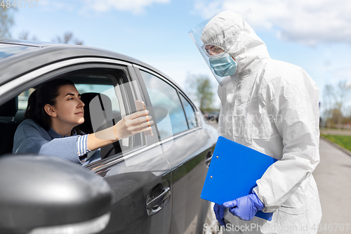 Image of woman in car showing phohe to healthcare worker