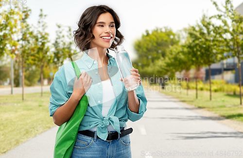 Image of woman with bag for food shopping and glass bottle