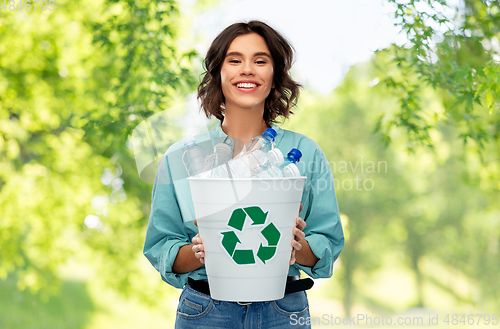 Image of smiling young woman sorting plastic waste