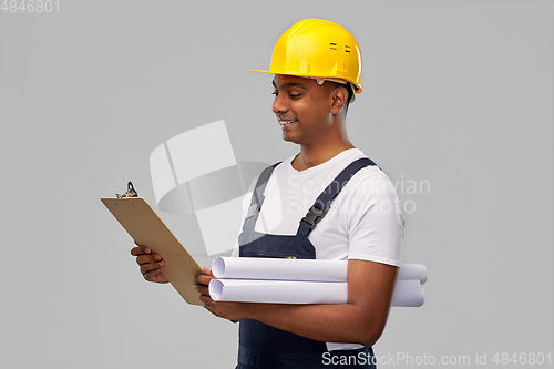 Image of happy indian builder with blueprint and clipboard