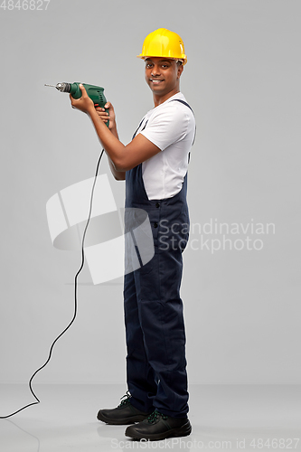 Image of happy indian builder in helmet with electric drill