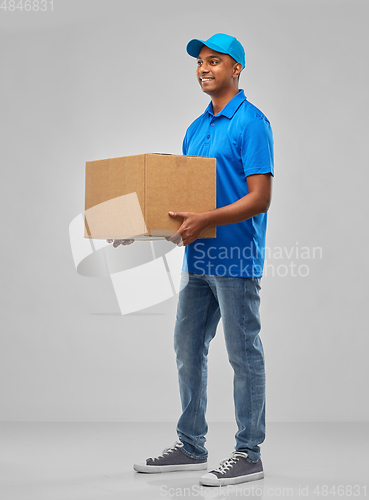 Image of happy indian delivery man with parcel box in blue