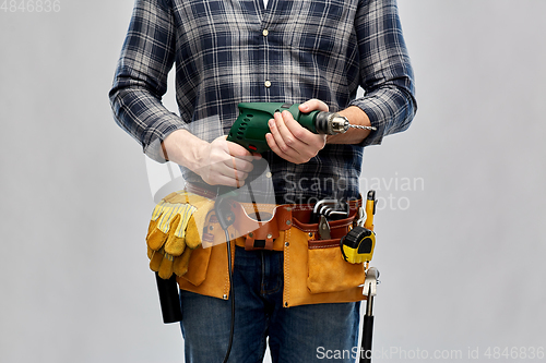 Image of male repairer or builder with drill and work tools