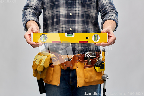 Image of male builder with level and working tools on belt