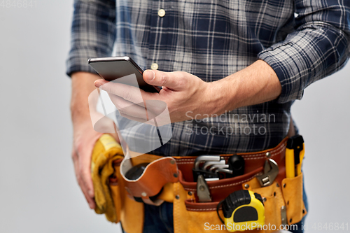 Image of worker or builder with phone and working tools